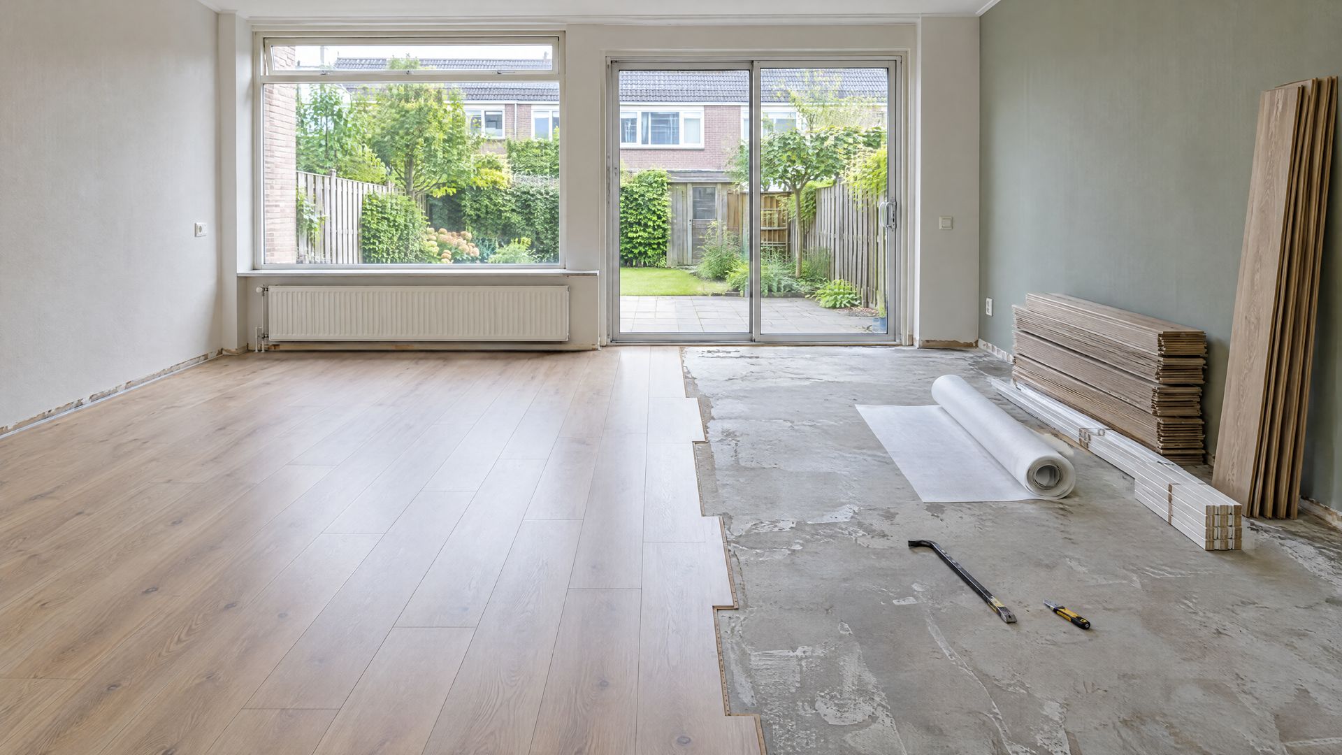 Woonkamer waar laminaat wordt opgenomen, met opgestapelde planken
