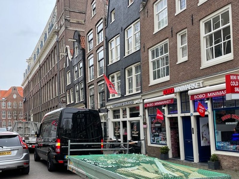 Bedrijfsbus en aanhanger in een stadsstraat
