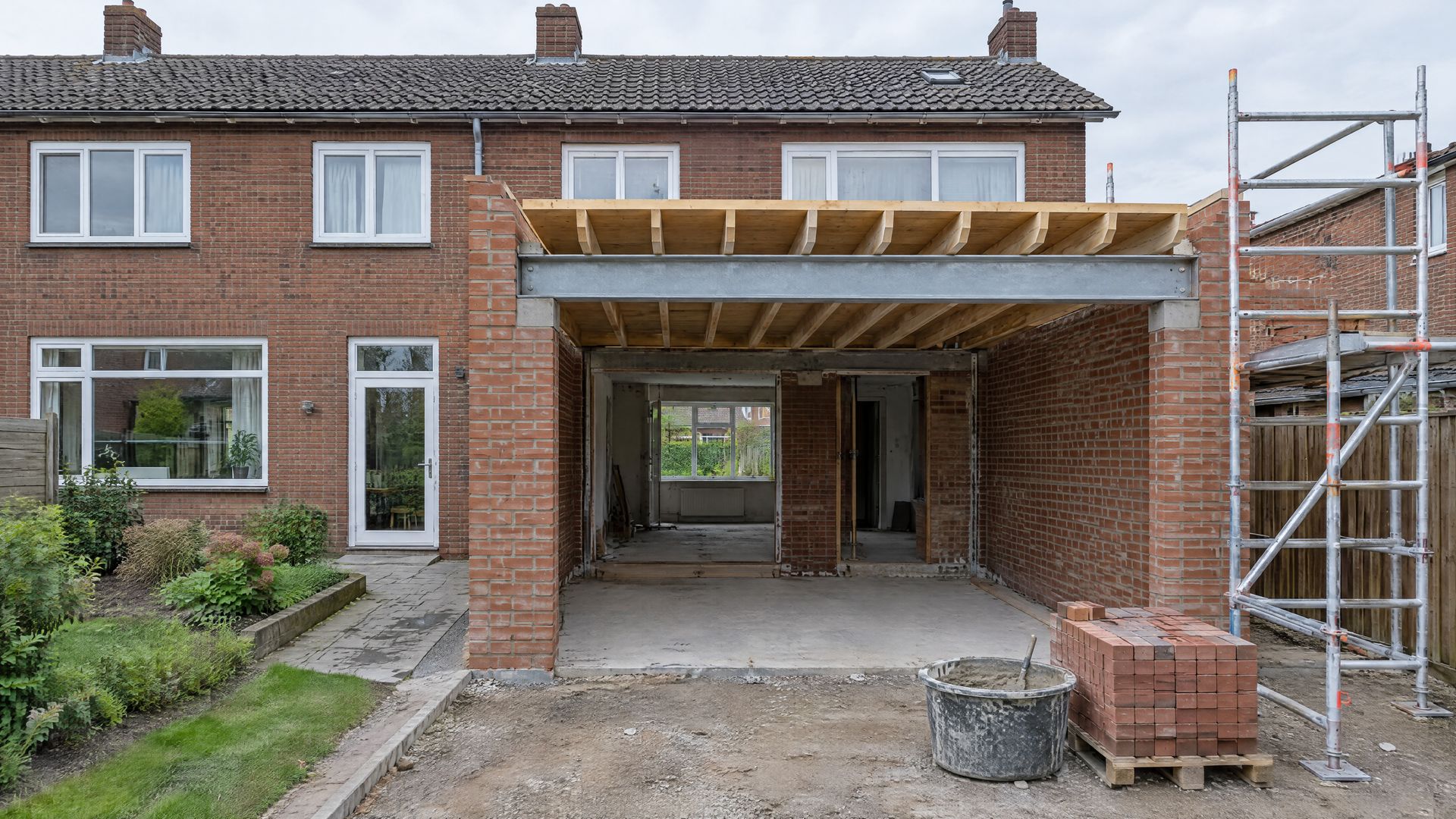 Rear extension in the shell stage, with new brickwork, a steel beam and scaffolding