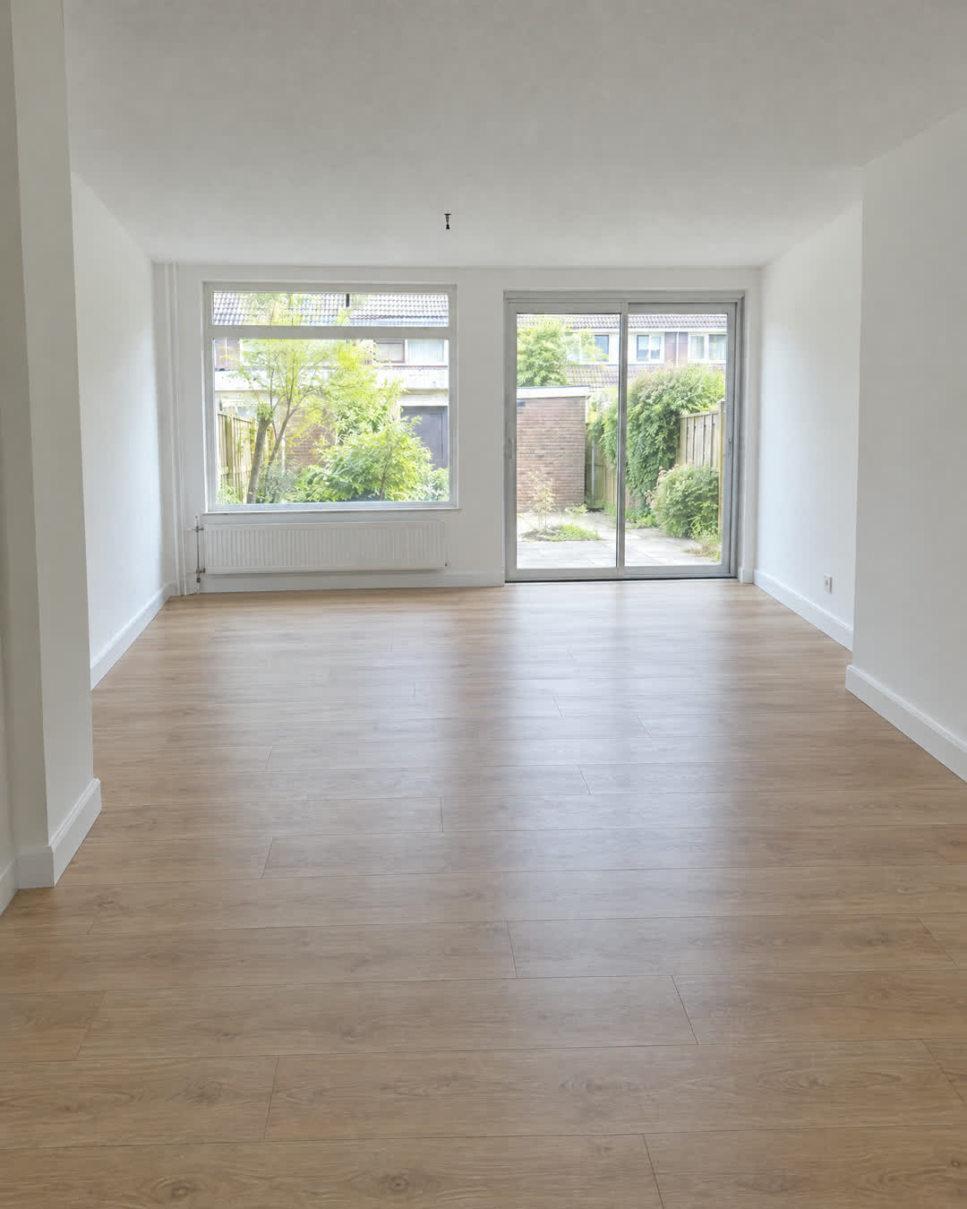 Voor: woonkamer met versleten licht eiken laminaat