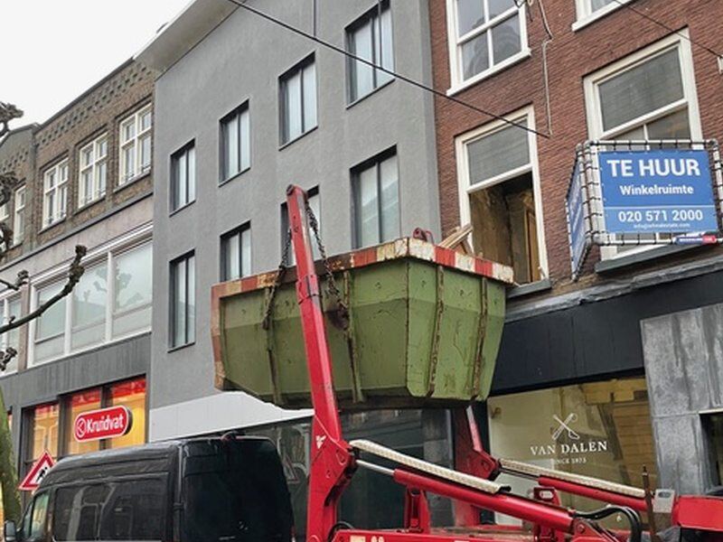 Container wordt met een kraan geplaatst in een winkelstraat