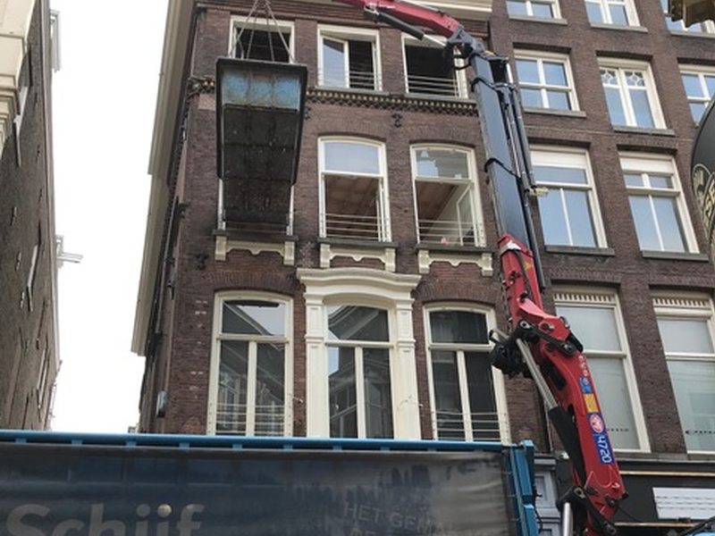 Kraan bij de gevel van een grachtenpand tijdens werkzaamheden