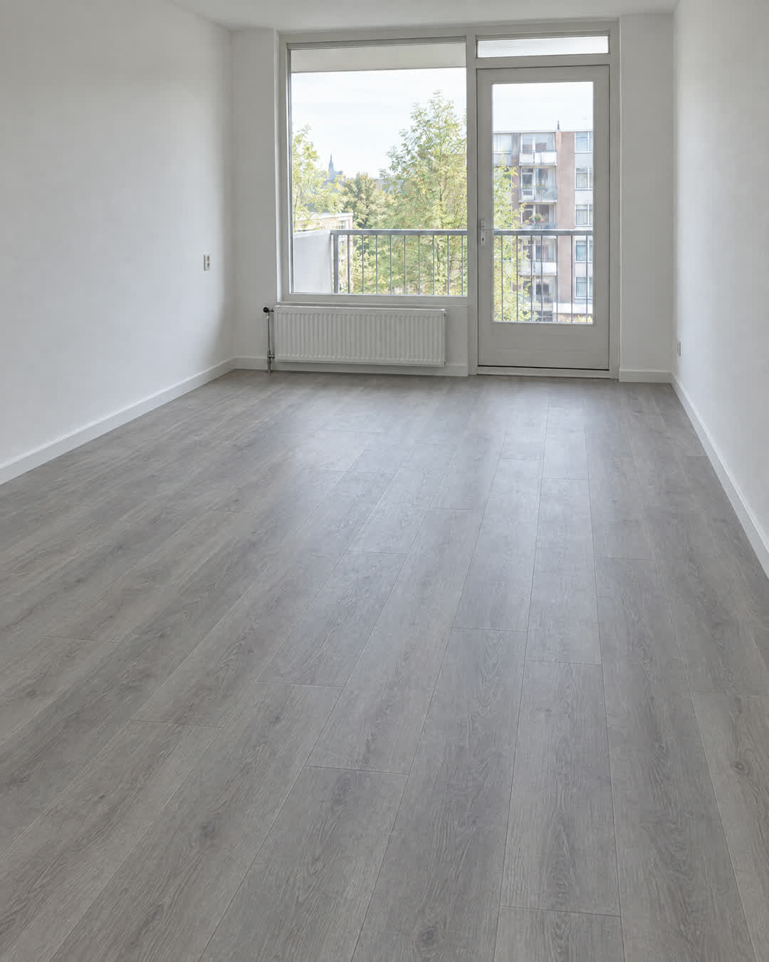 Voor: kamer met een grijze PVC-vloer in houtlook