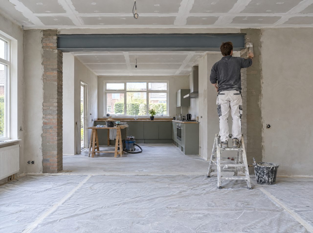 Vakman werkt de wand af bij een nieuwe doorbraak met stalen balk